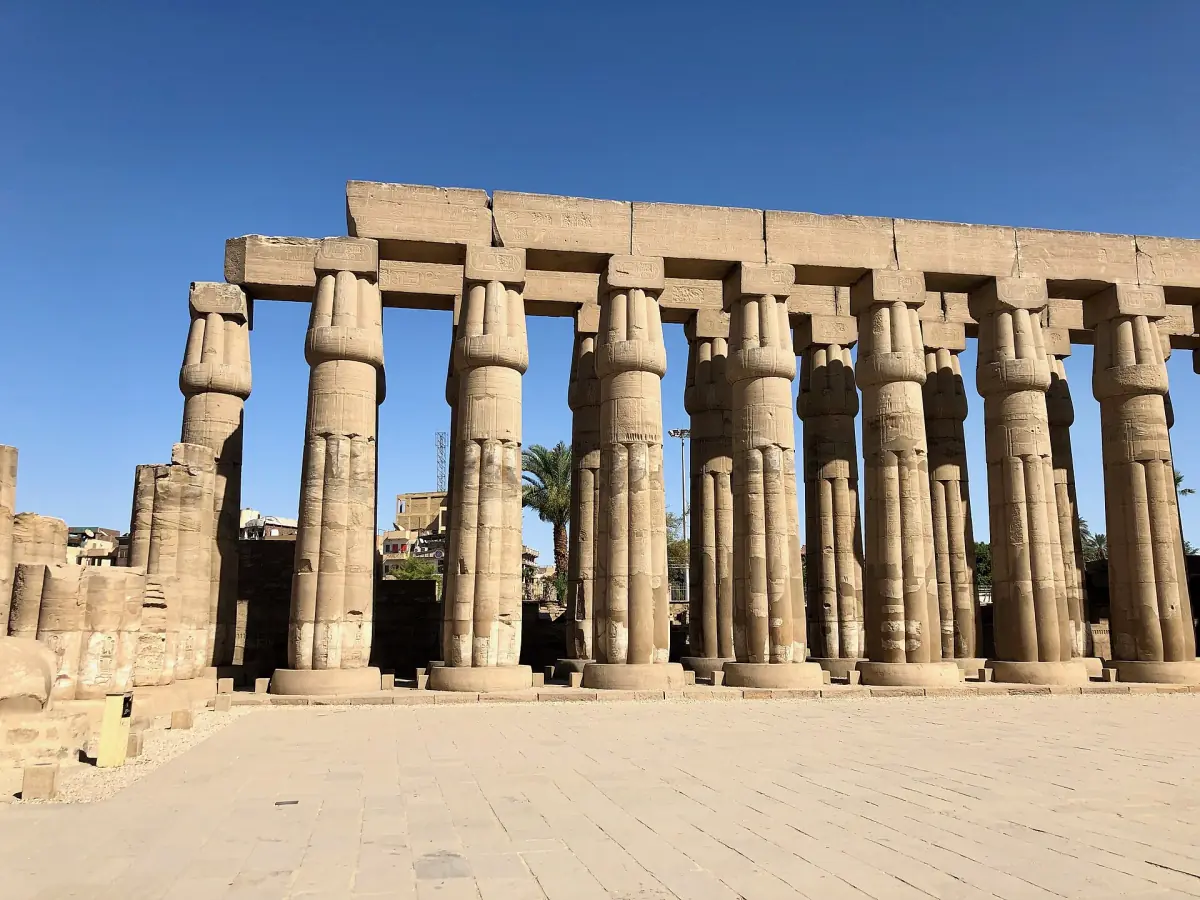 Row of large columns with architraves in Luxor Temple under a blue sky