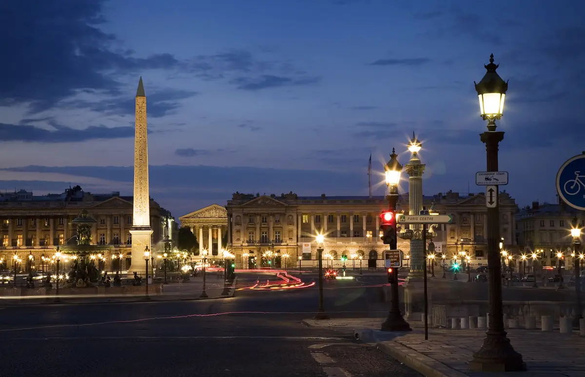 Luxor Obelisk on Place de la Concorde at dusk with street lamps lit