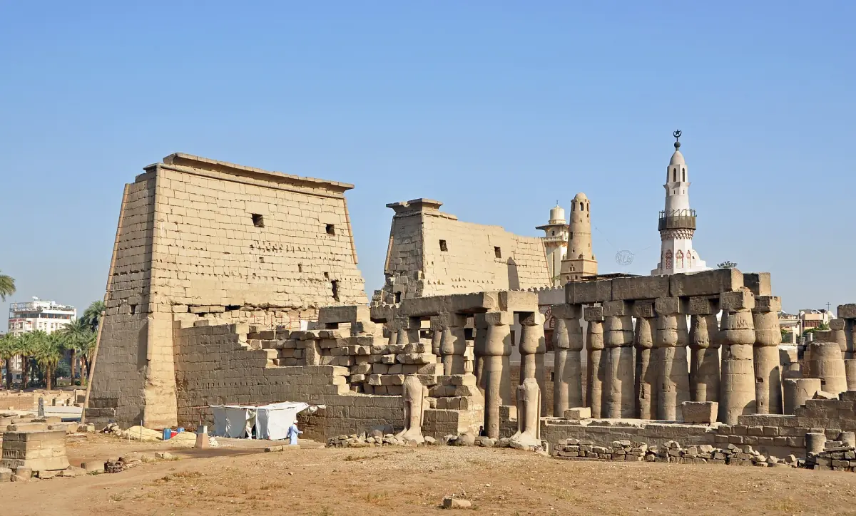 Temple de Louxor avec son pylône, sa colonnade et le minaret d’une mosquée en arrière-plan