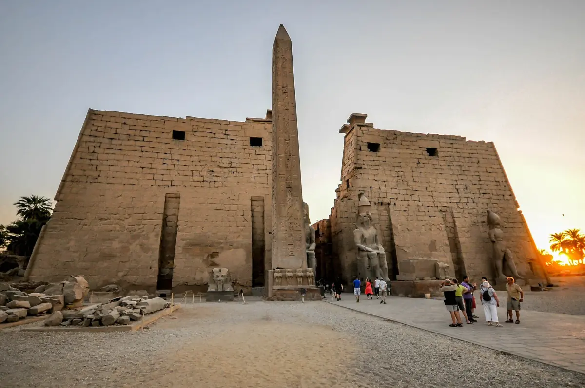 Pylône du temple de Louxor avec un seul obélisque et des statues assises à la lumière du jour