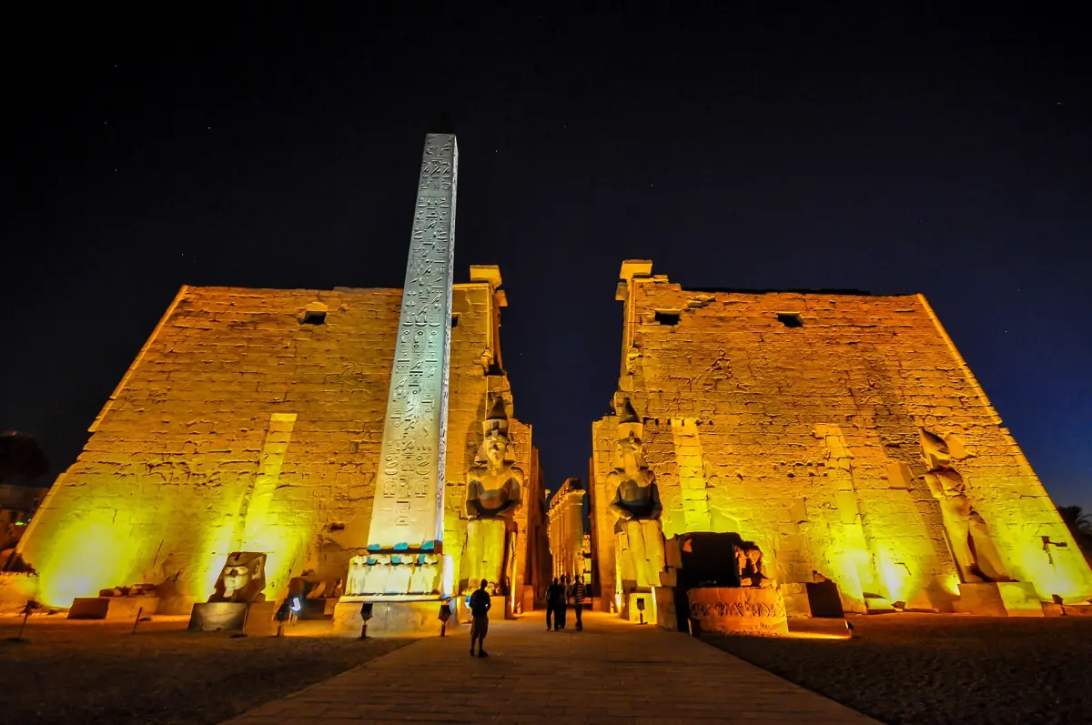 Pylône, obélisque et statues du temple de Louxor illuminés sur fond de ciel nocturne
