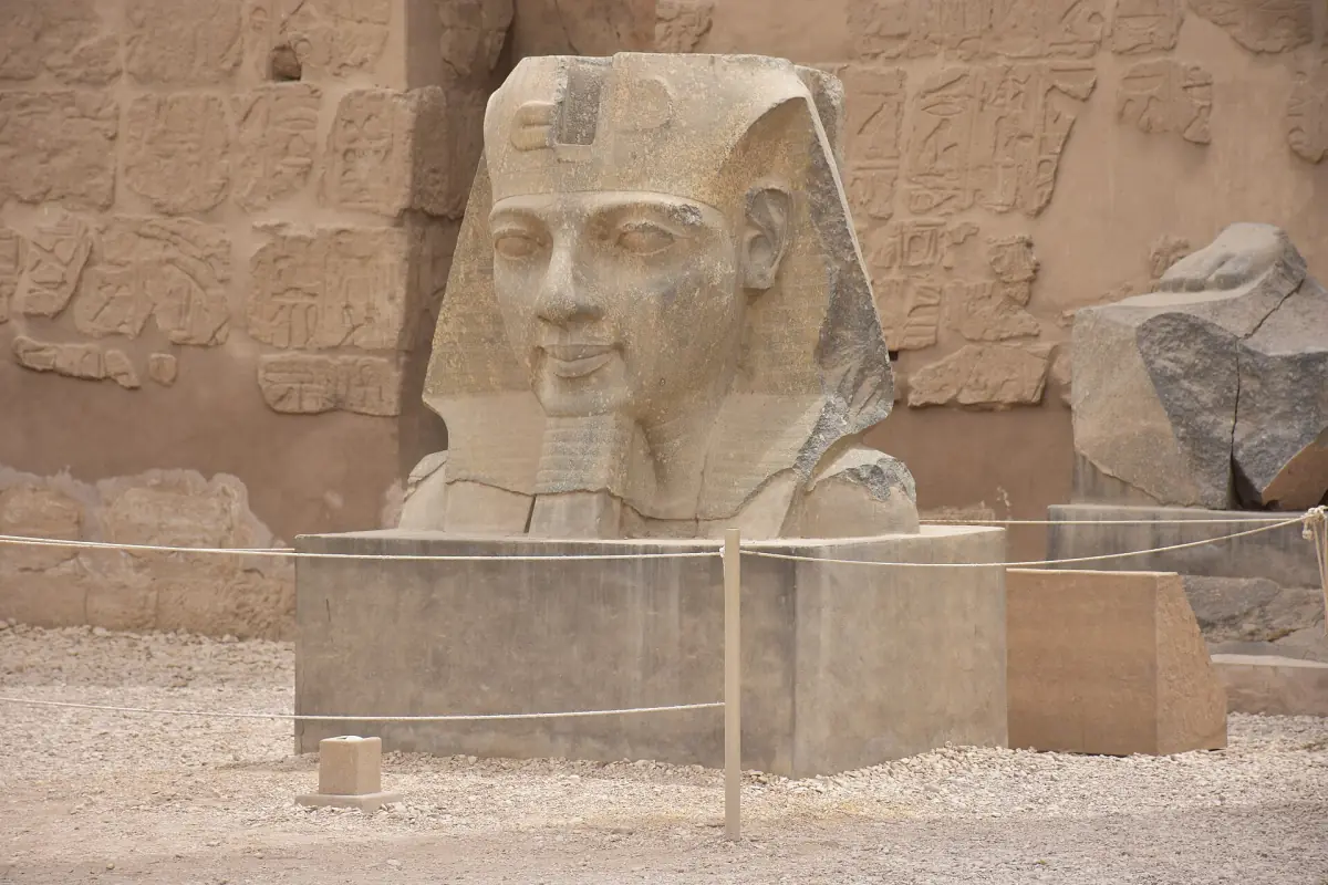 Stone head of a seated pharaoh statue at Luxor Temple with a nemes headdress