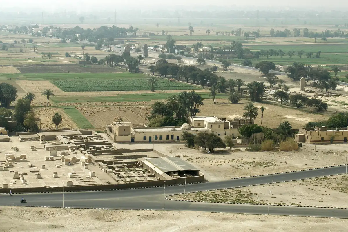Champs verdoyants de la plaine thébaine avec une route et des ruines près de Louxor